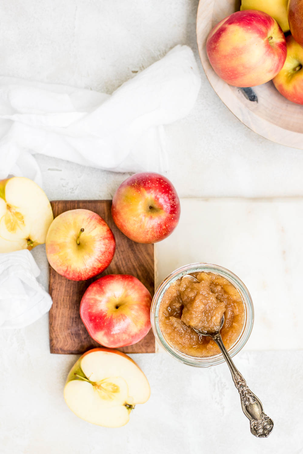 overhead homemade apple sauce in jar next to bowl of apples