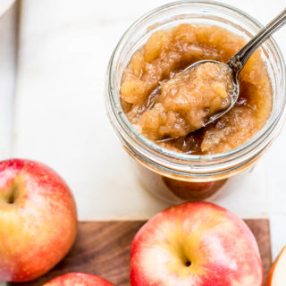 homemade apple sauce in jar next to apples