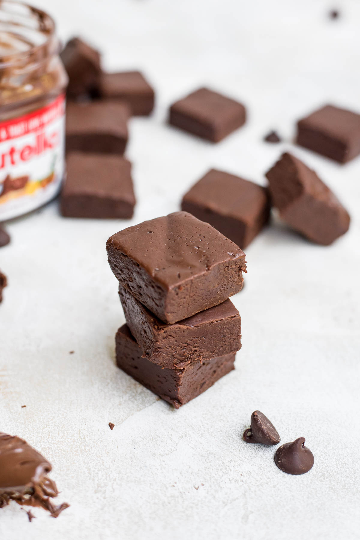 Stacked nutella fudge with Nutella jar in background