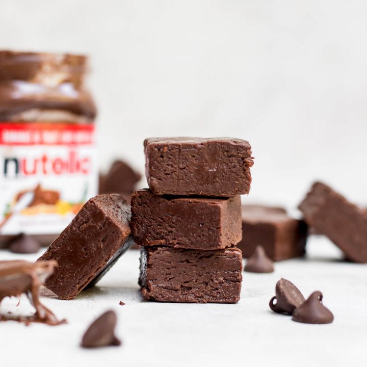 stacked nutella fudge with nutella jar in background