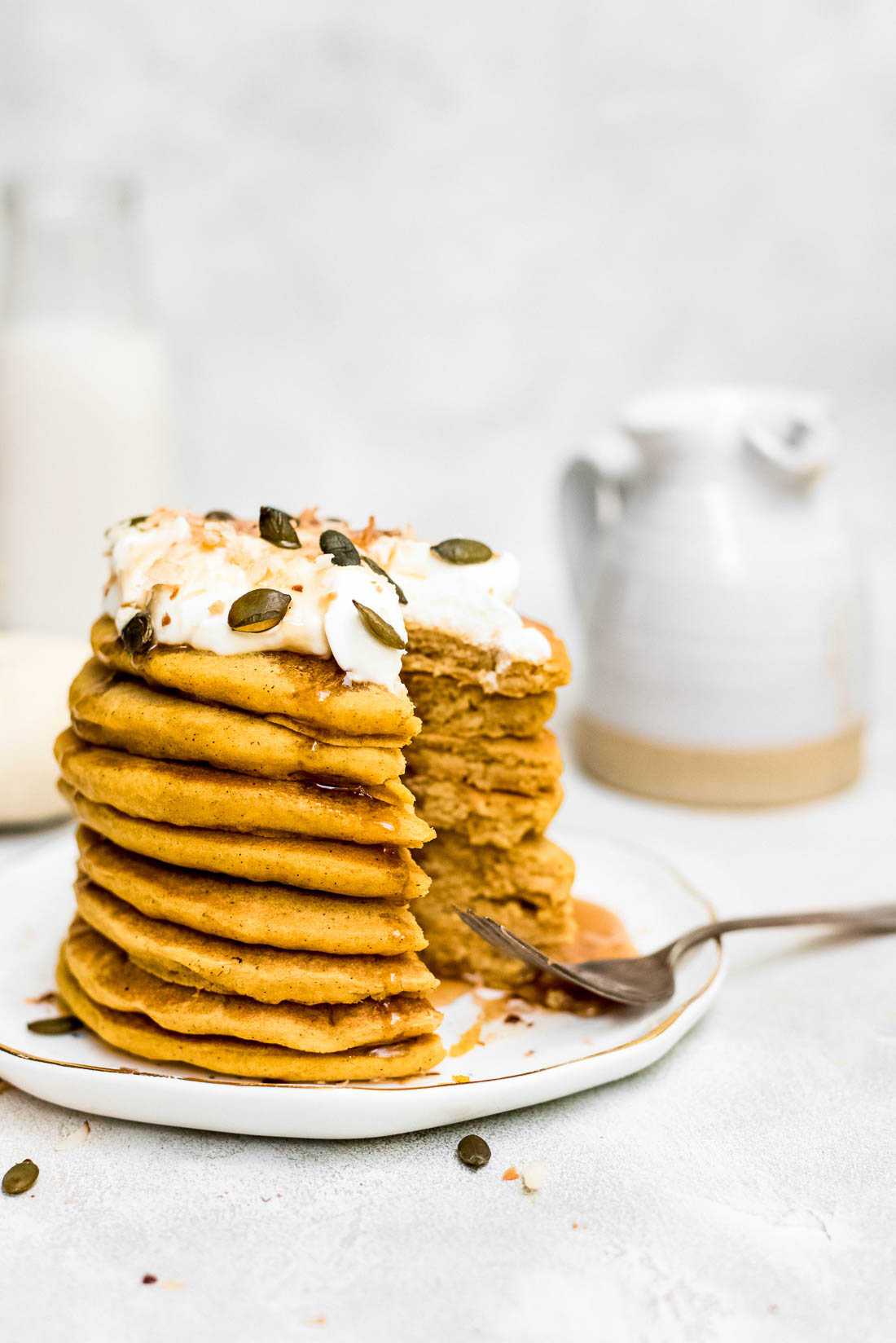 pumpkin pancakes drizzled with syrup being eaten close up