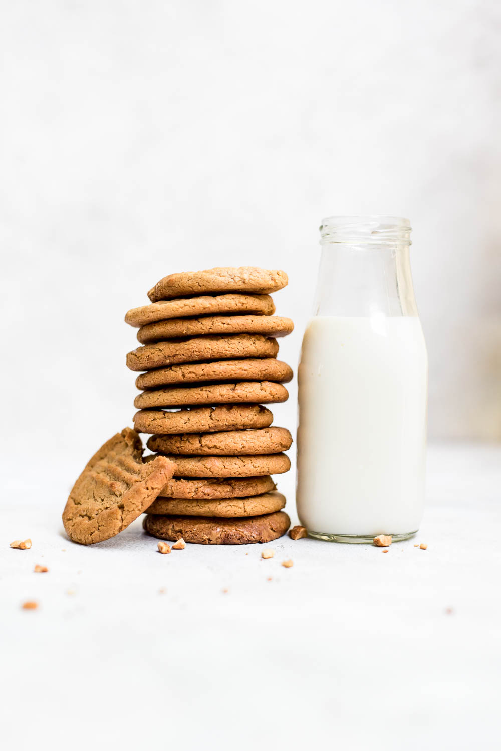 3 ingredient peanut butter cookies stacked next to jug of milk