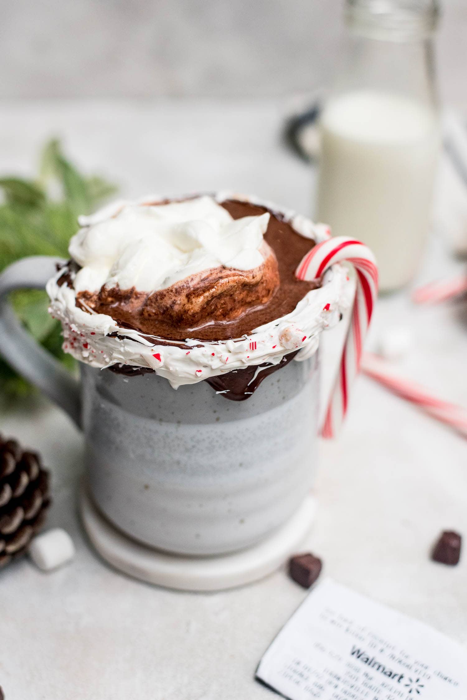 hot chocolate topped with whipped cream and mini candy cane