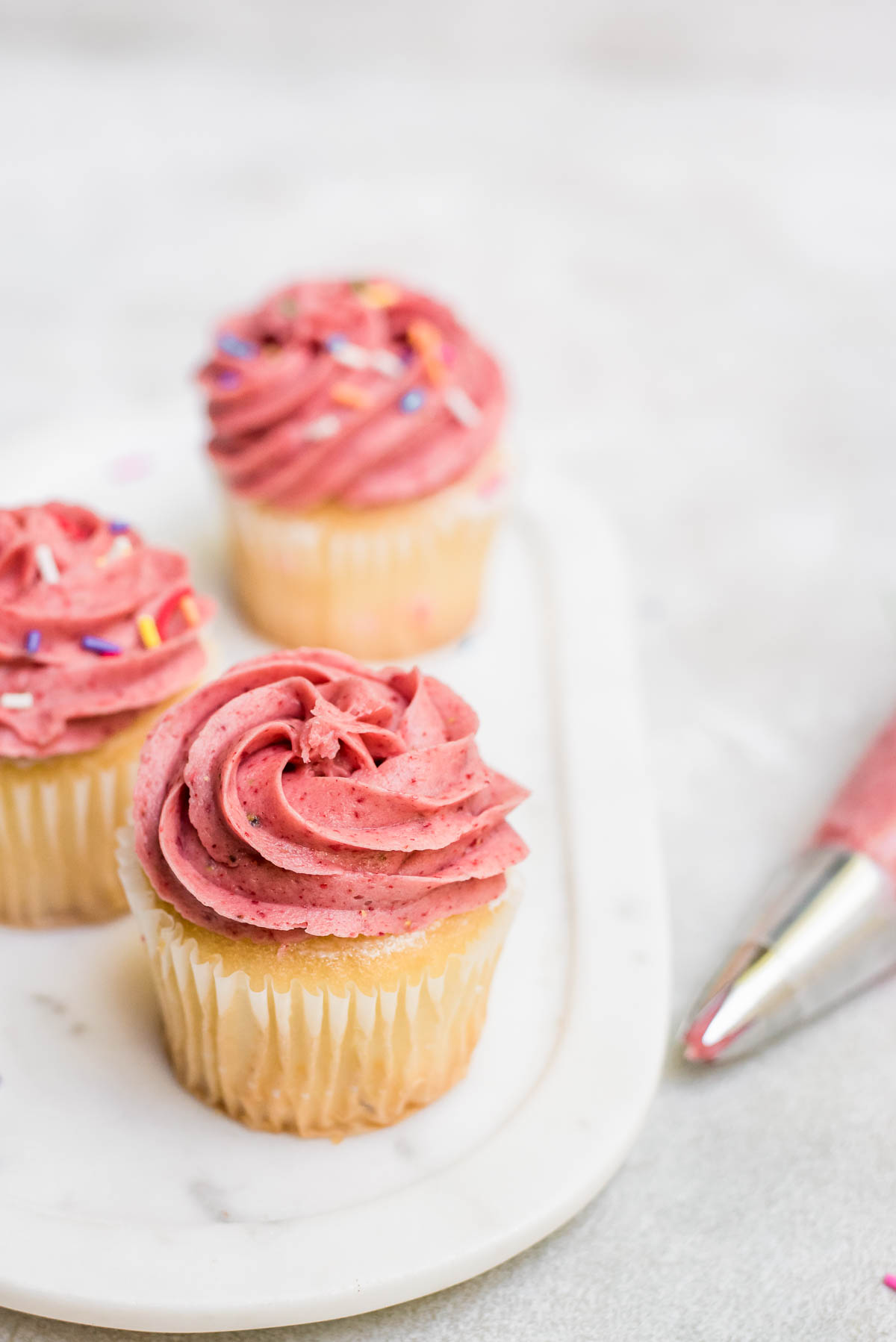 strawberry frosting topped with creamy strawberry frosting on tray