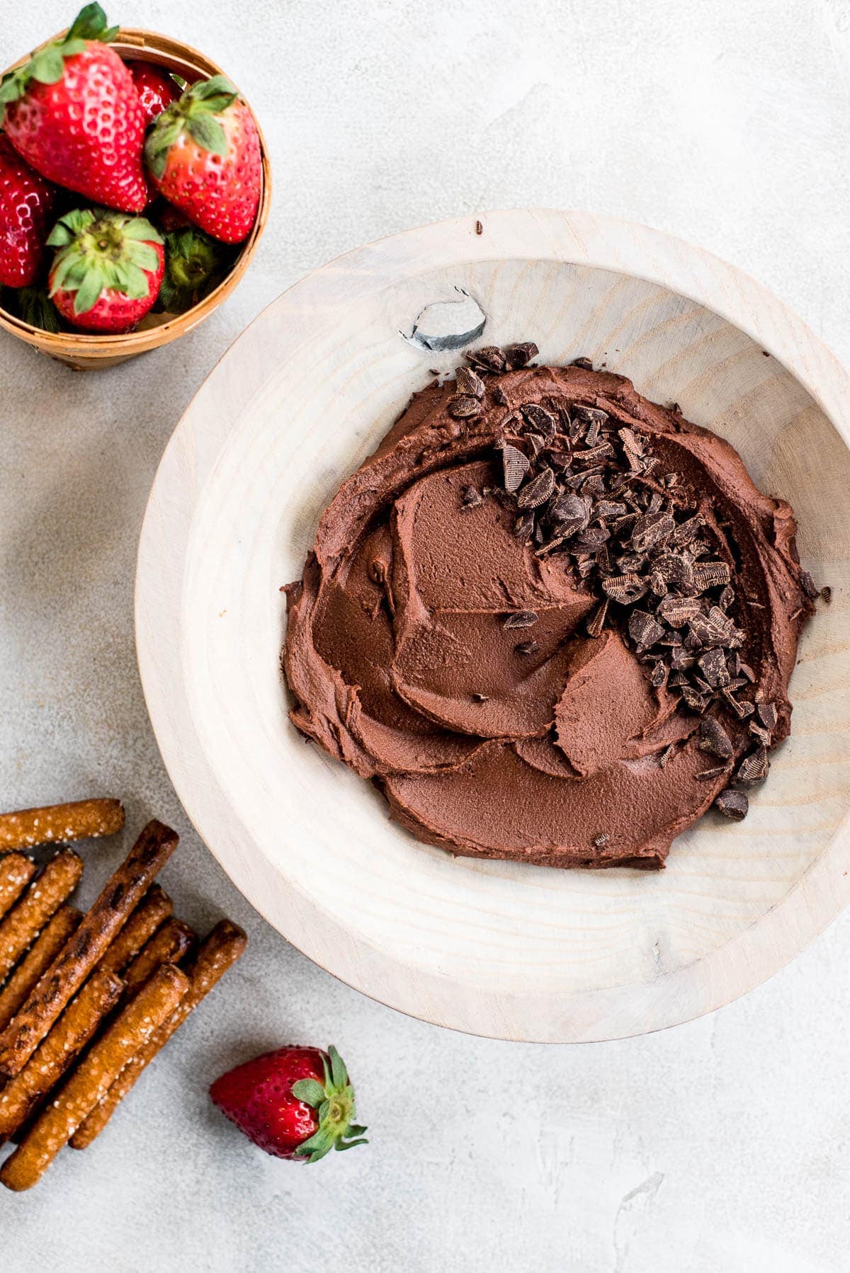 brownie batter hummus in wood bowl with fruit and pretzels