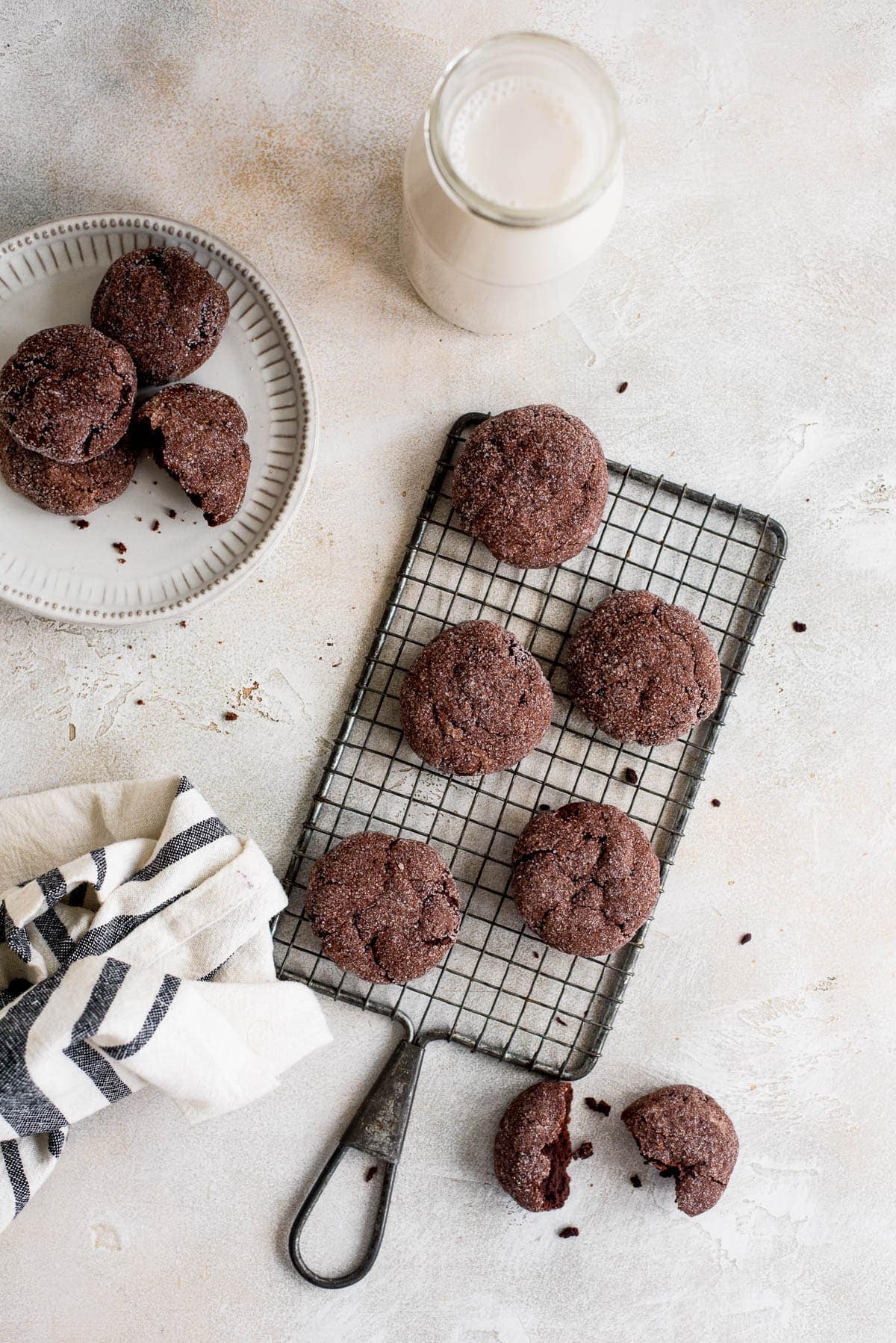 overhead chocolate sugar cookies on wire rack and plates with glass of milk