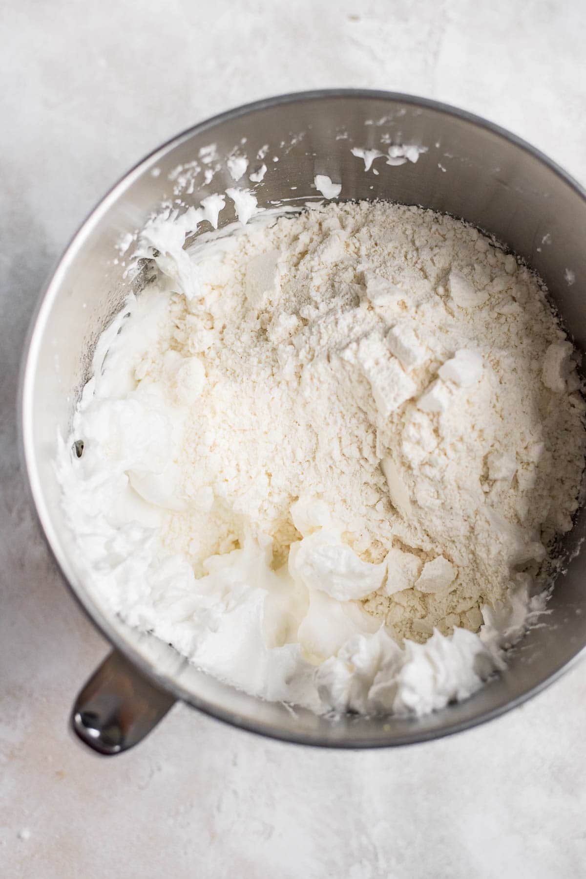adding almond flour and powdered sugar to meringue