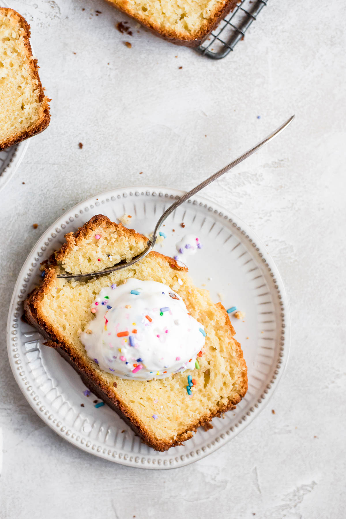 cake on plate with ice cream, sprinkles, and fork