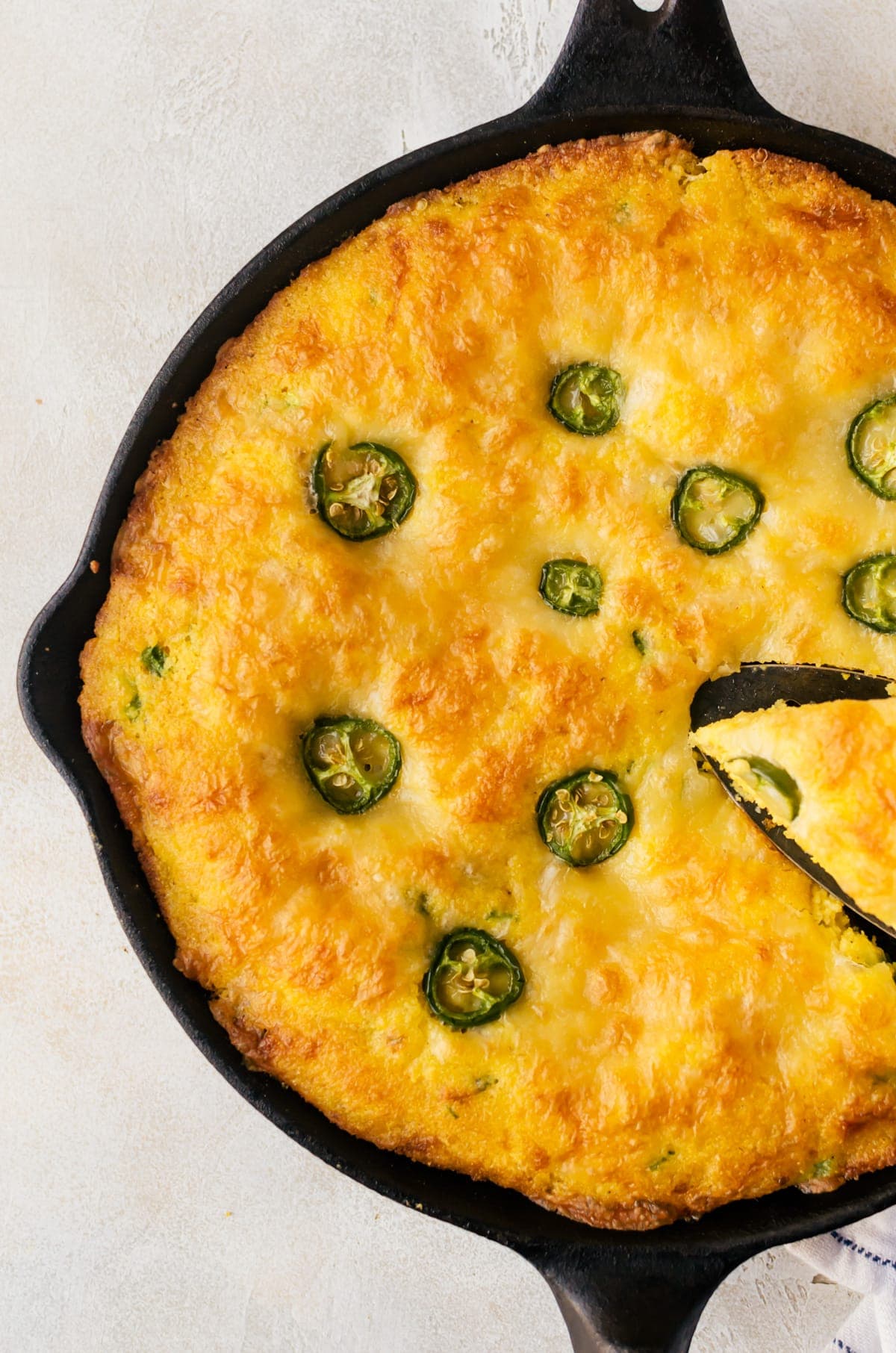 close up of cornbread in skillet showing sliced jalapenos