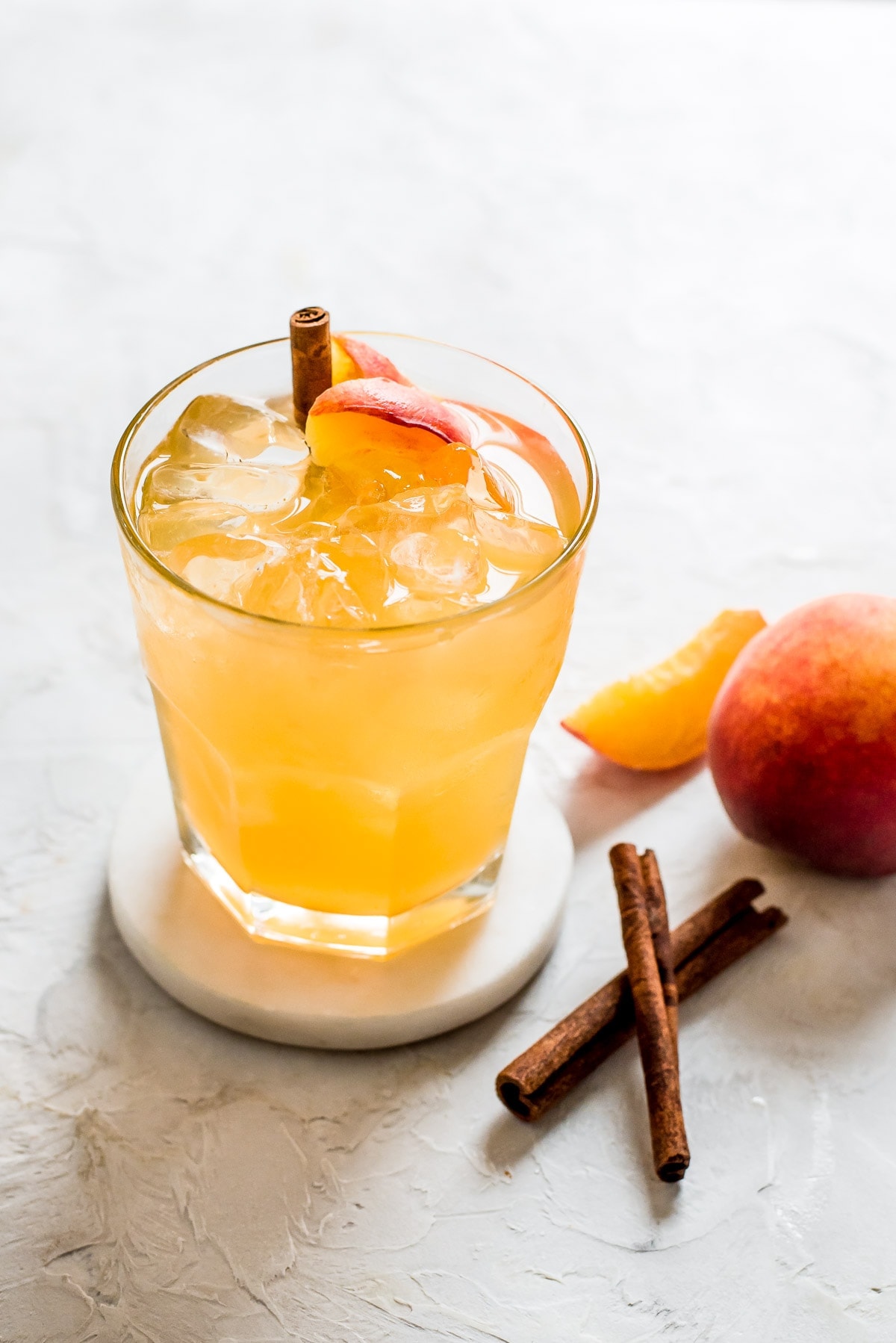 backlit glass filled with ice and moonshine with cinnamon stick garnish