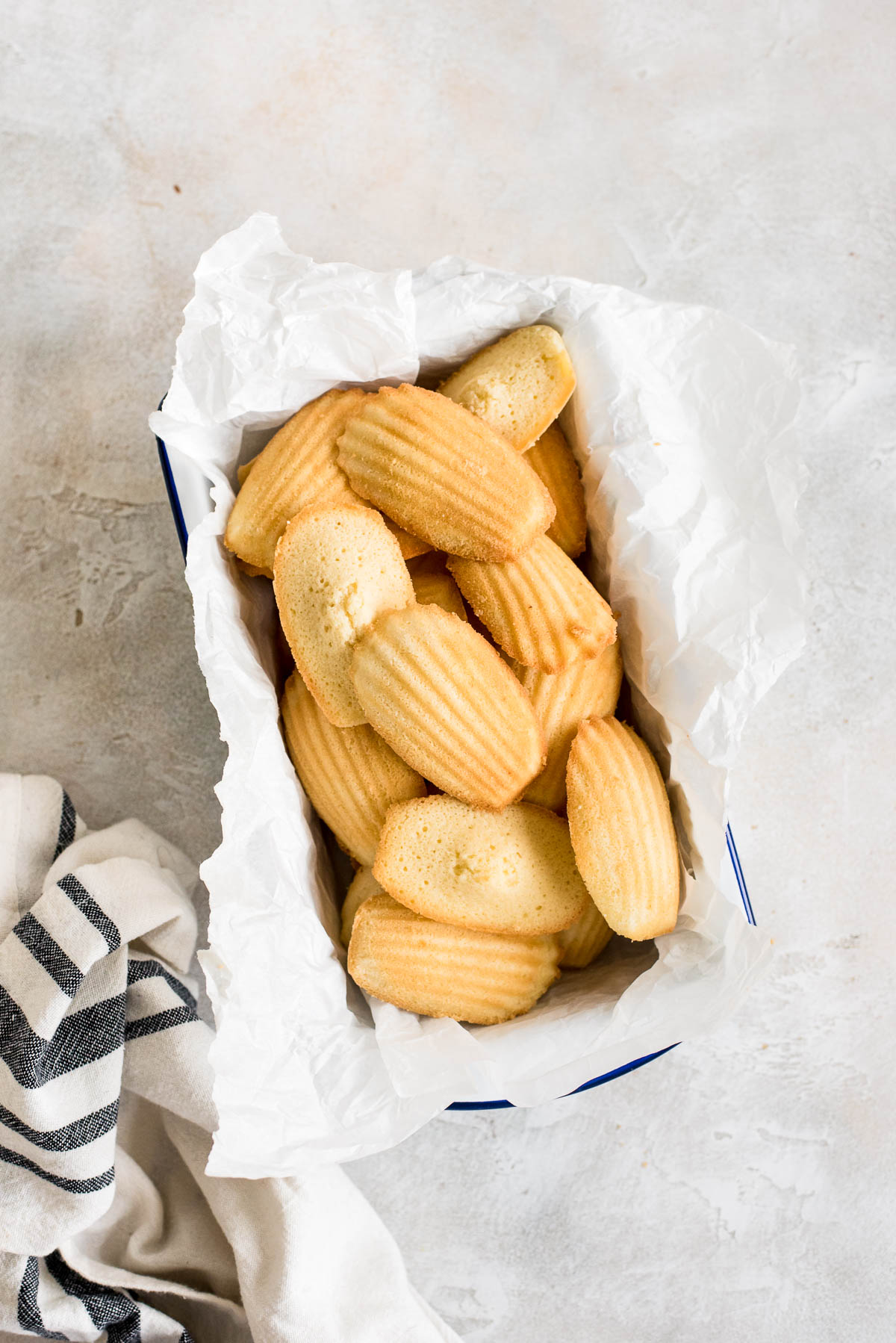 madeleines in a container with parchment paper