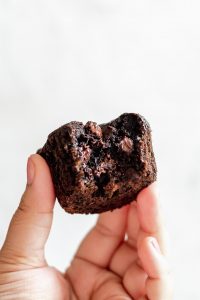 hand holing muffin showing gooey chocolate