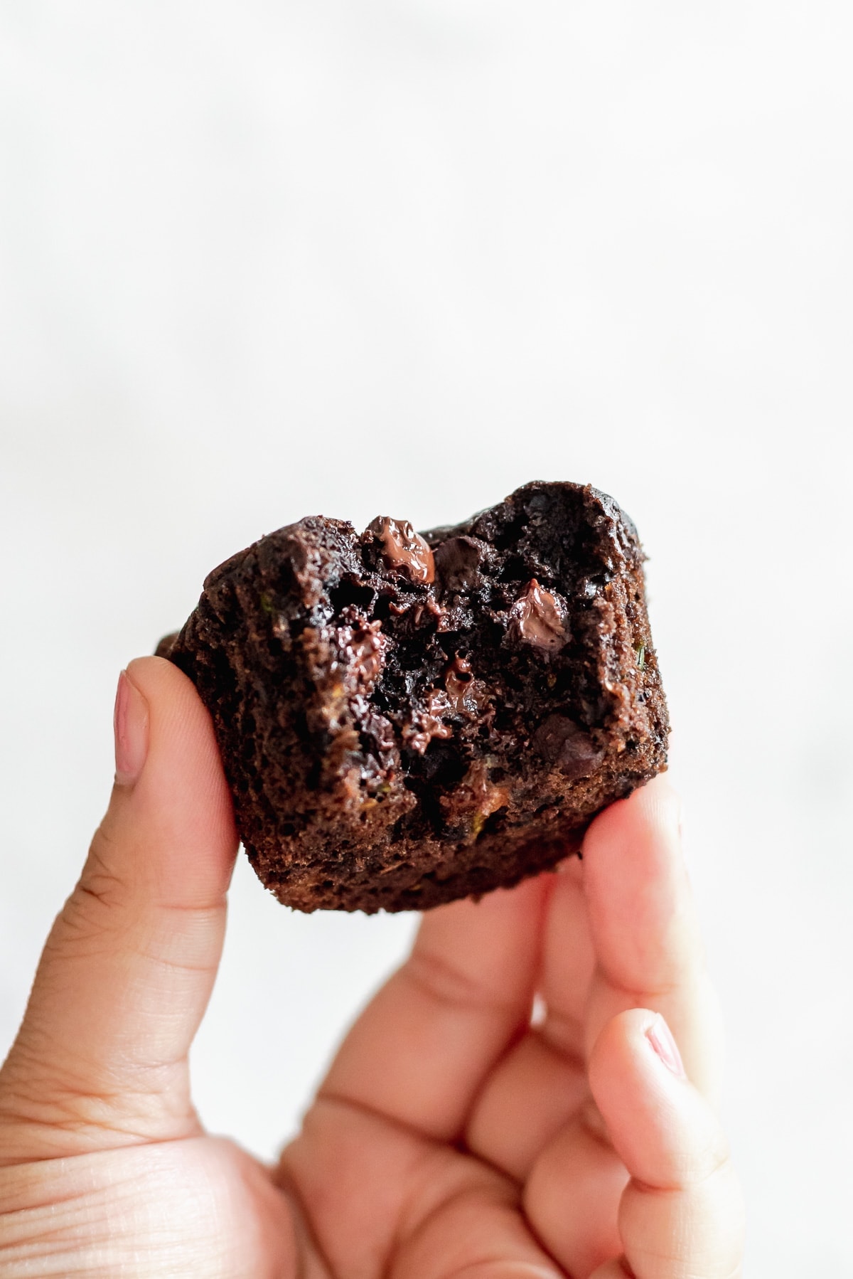 hand holding muffin showing gooey chocolate