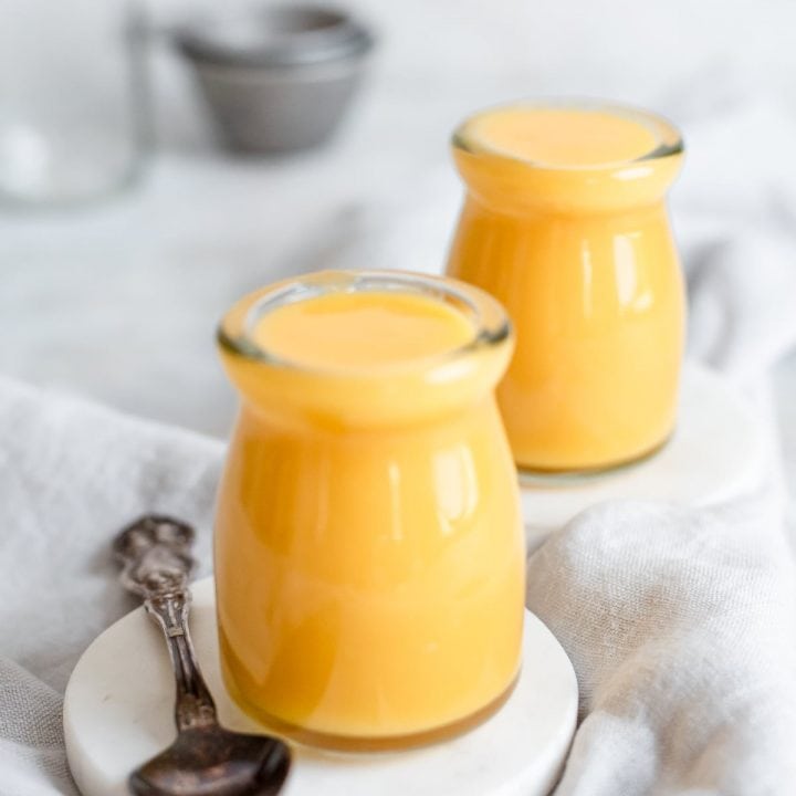 jars of fruity curd on coasters with a grey kitchen towel