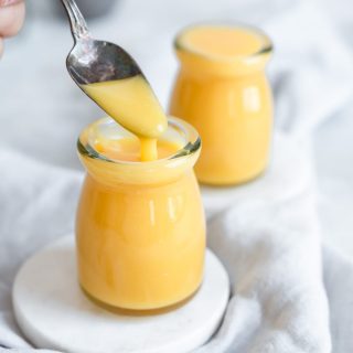 spoon drizzling curd into jar