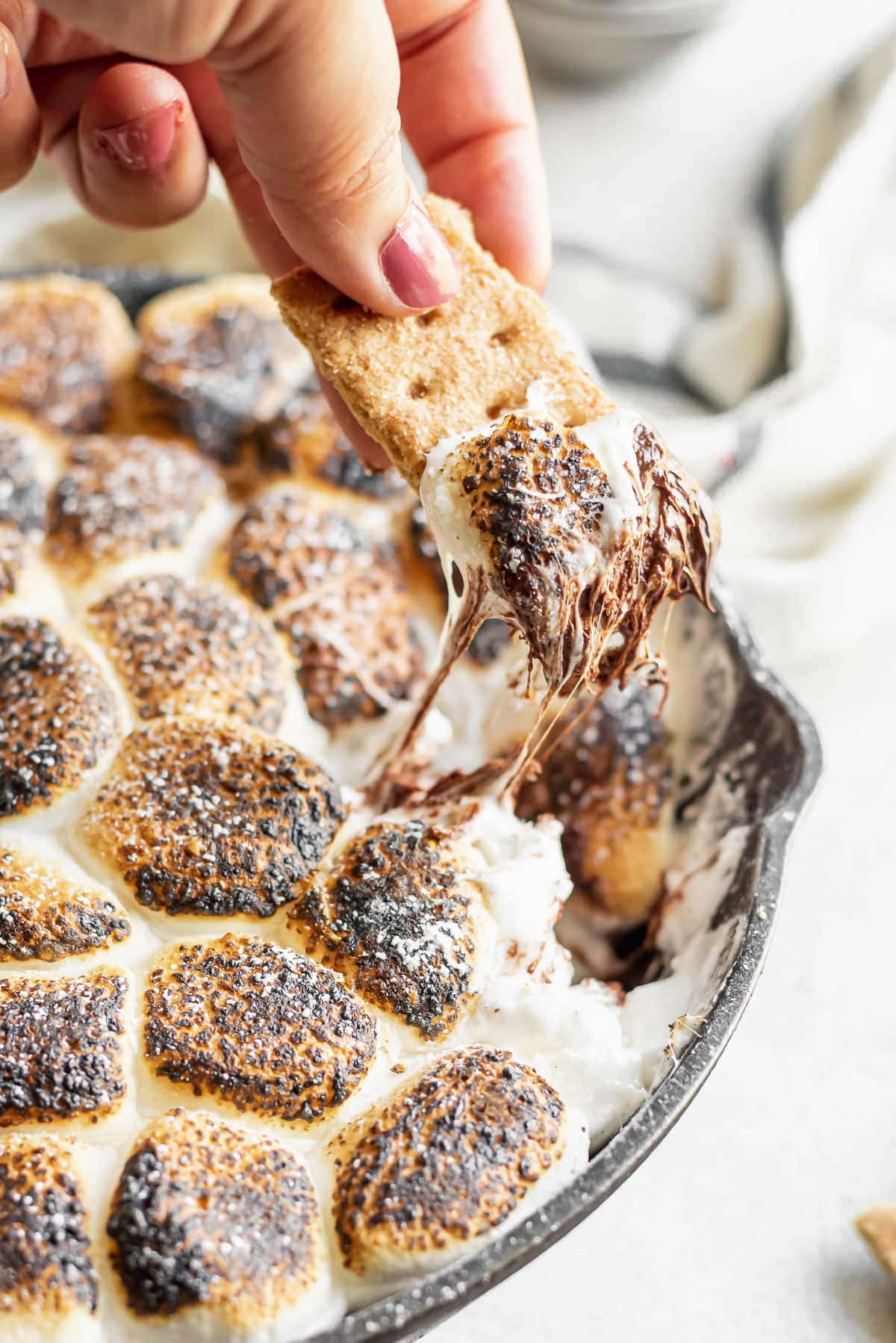 graham cracker being pulled from dip showing gooey chocolate