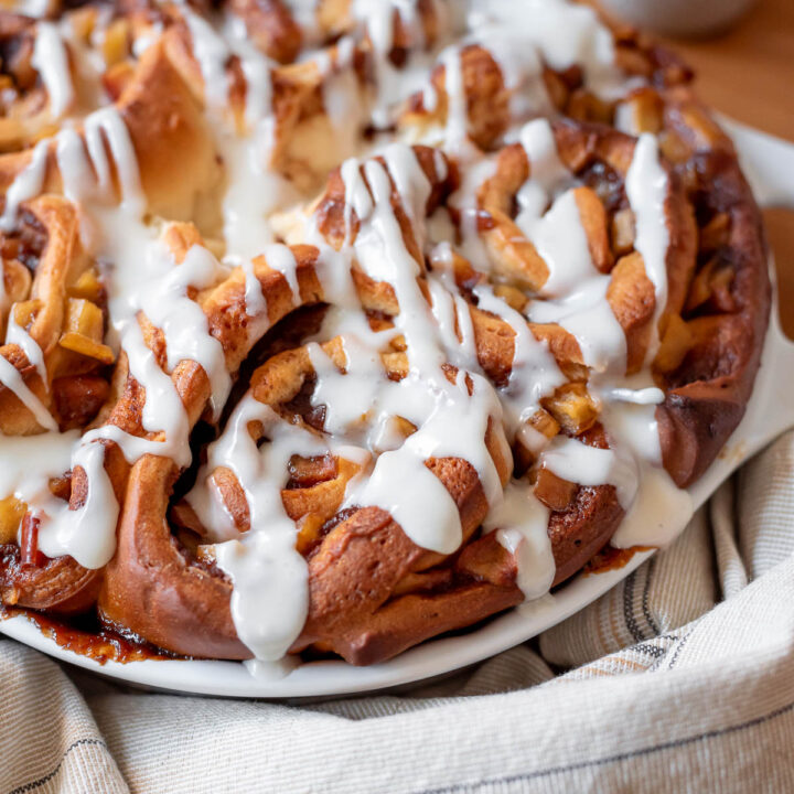 close up of finished cinnamon rolls covered in icing