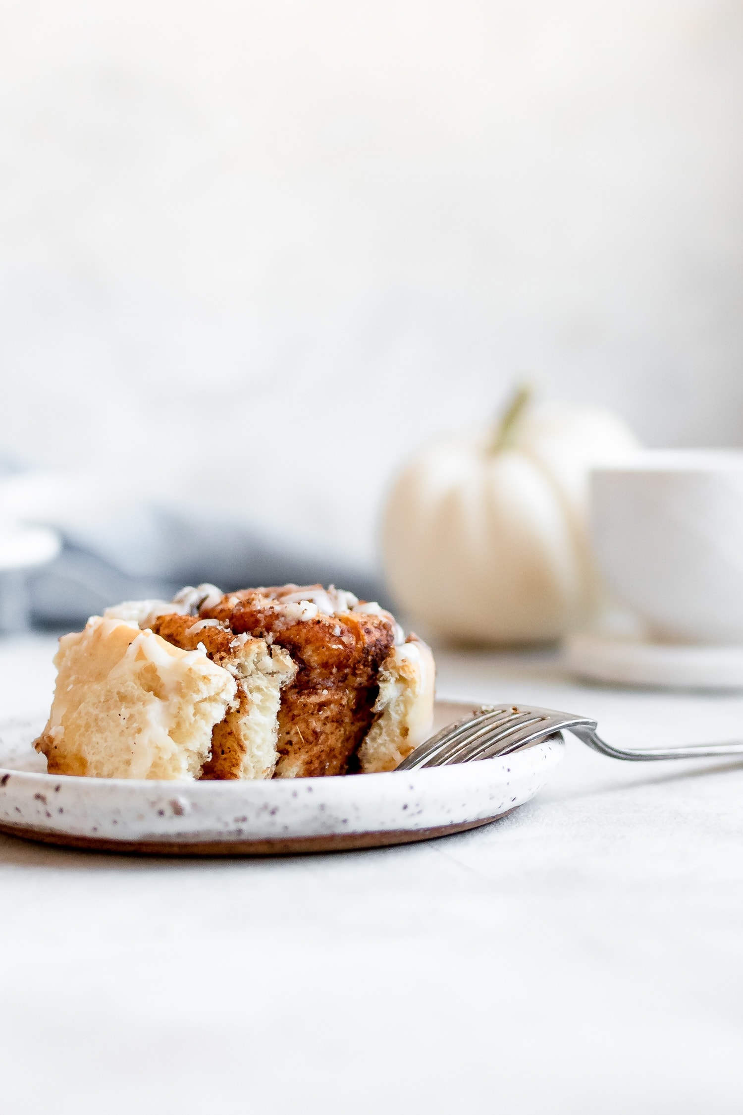 cinnamon roll on plate with bite missing