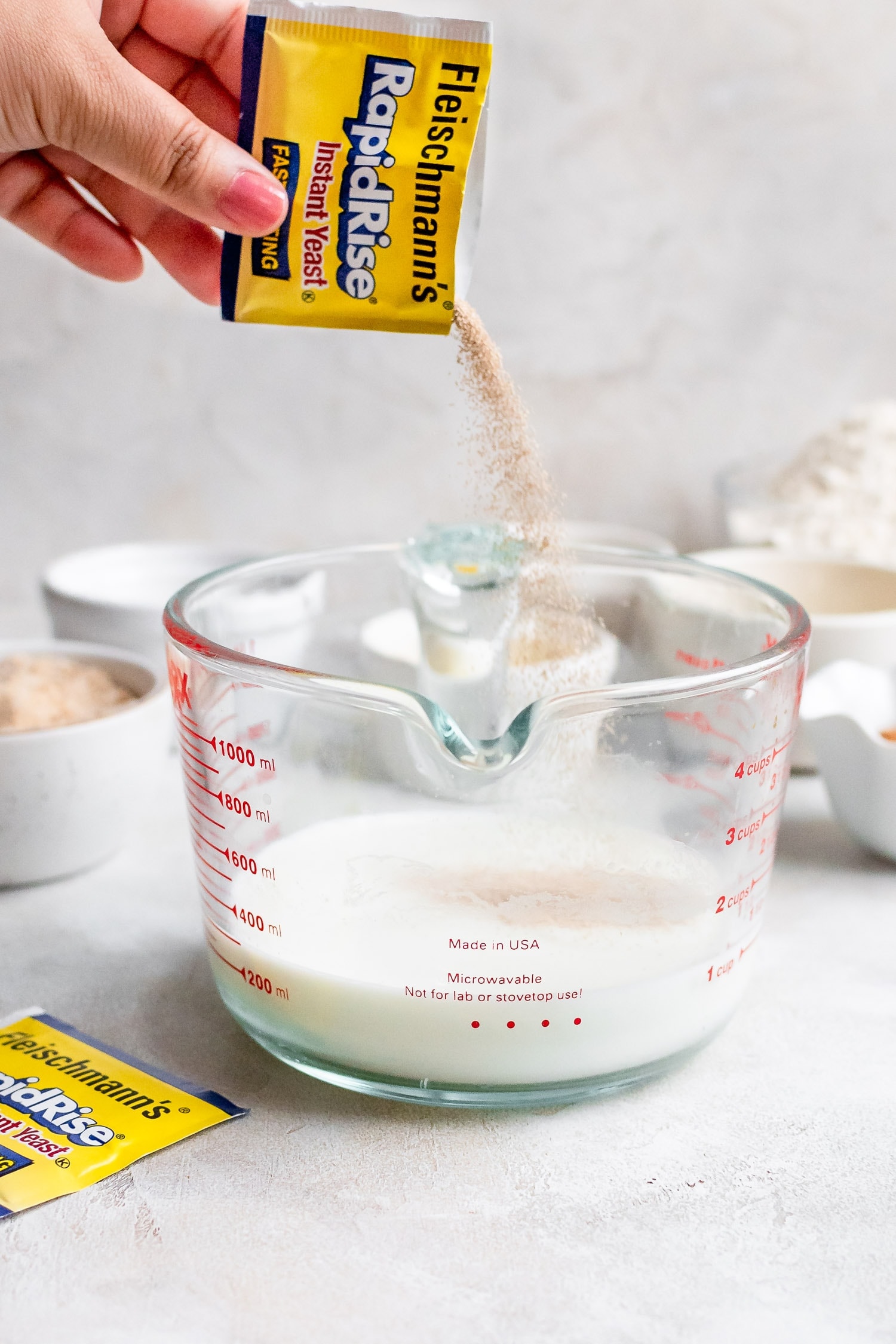 pouring yeast into glass of milk