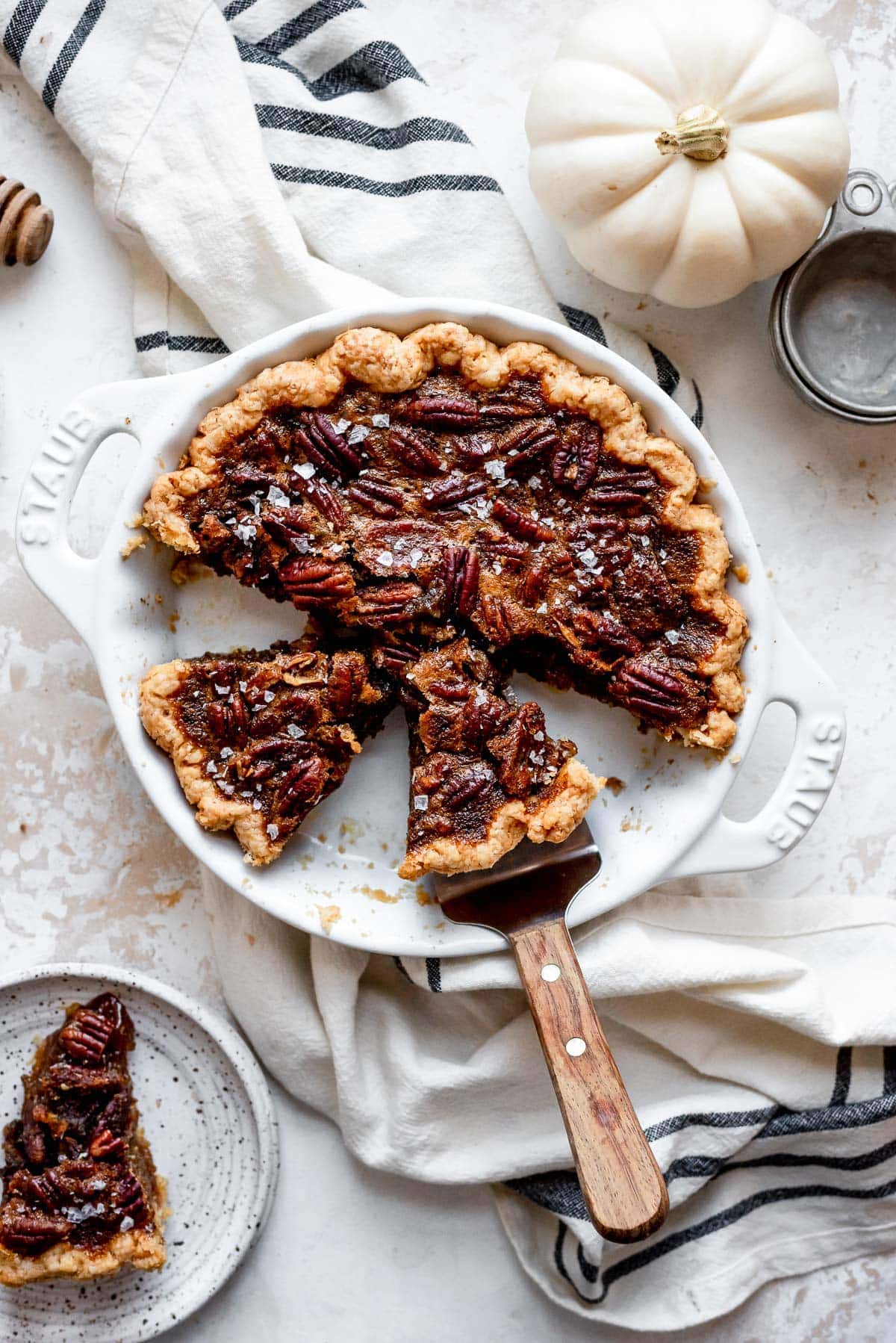 pie in pie pan with slices being plated