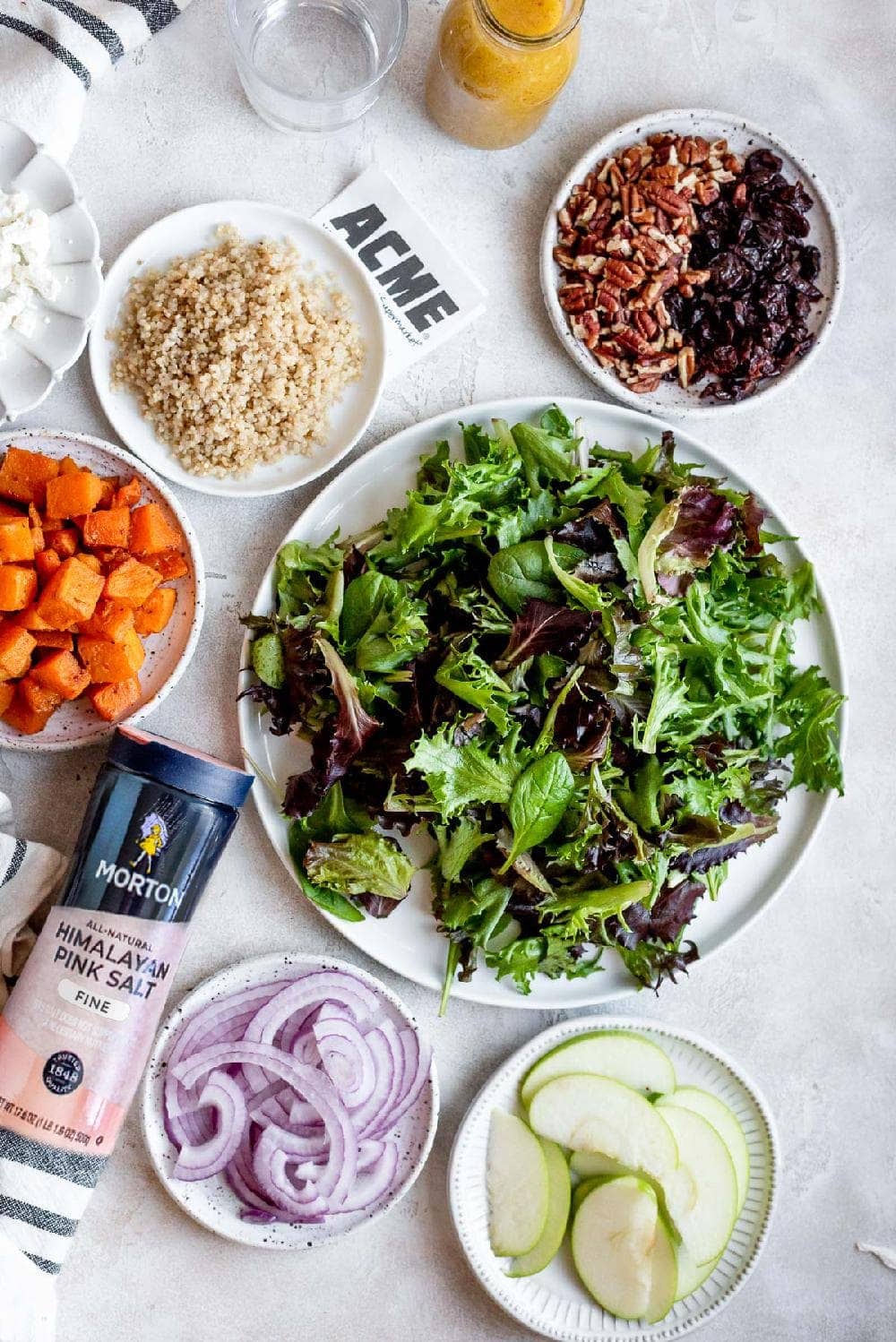 all the ingredients for salad on smal plates next  to dressing 