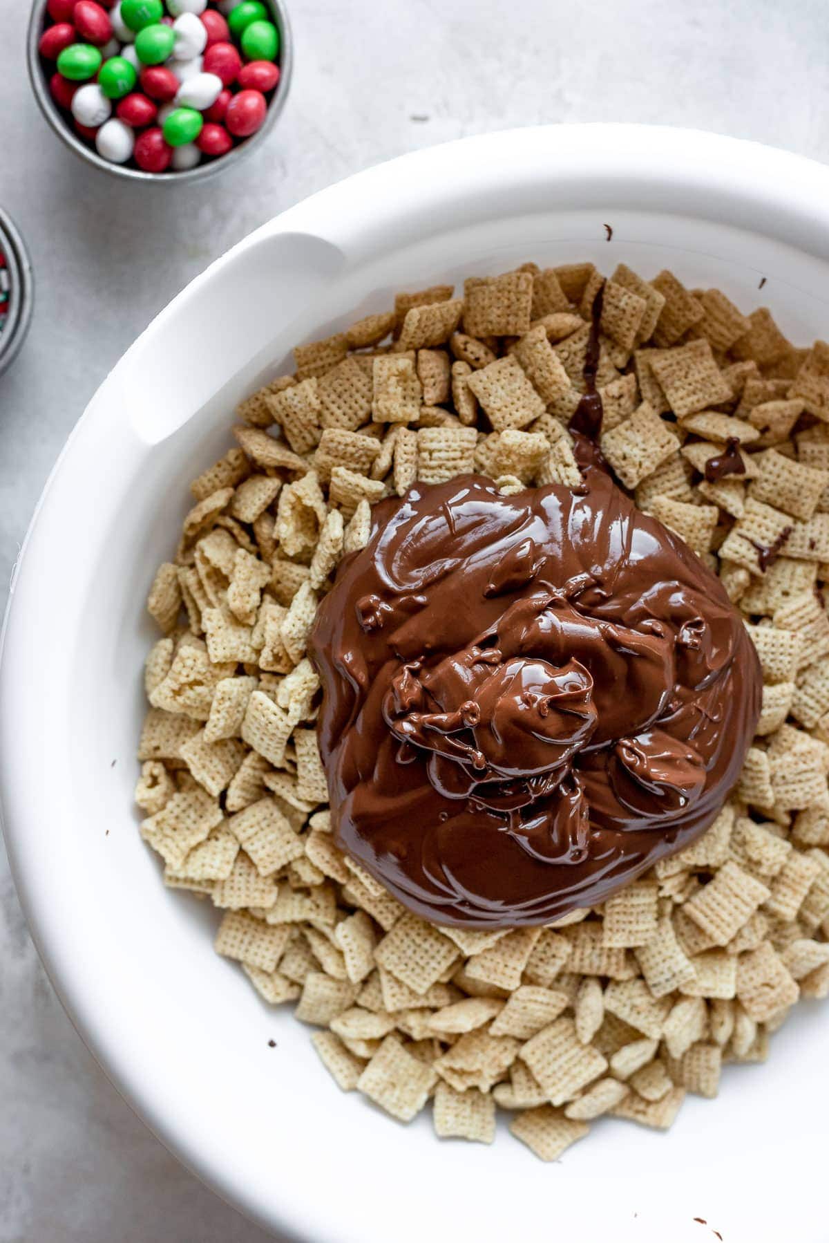Chex cereal in bowl topped with mix of melted chocolate, peanut butter, vanilla, and butter