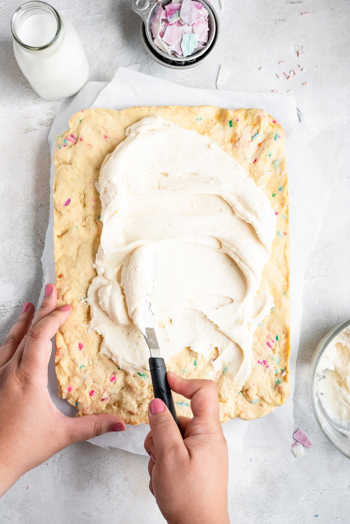 spreading frosting on sugar cookie bars