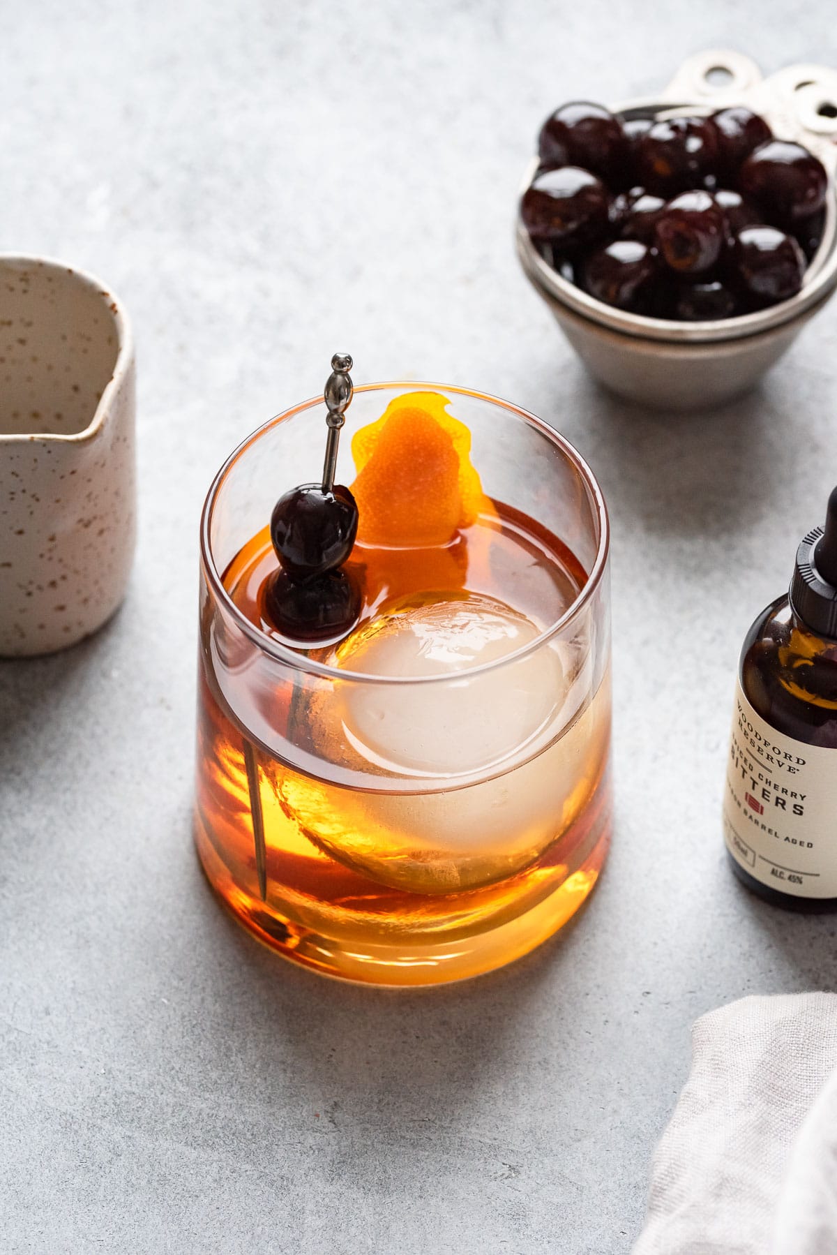 looking down at maple old fashioned with cherry and orange garnish