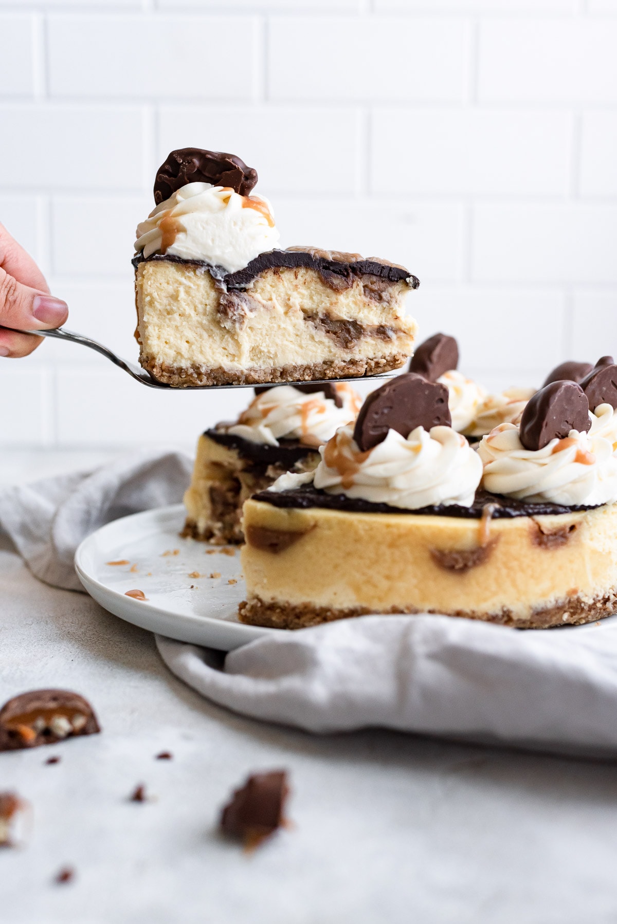 hand holding slice from turtle cheesecake