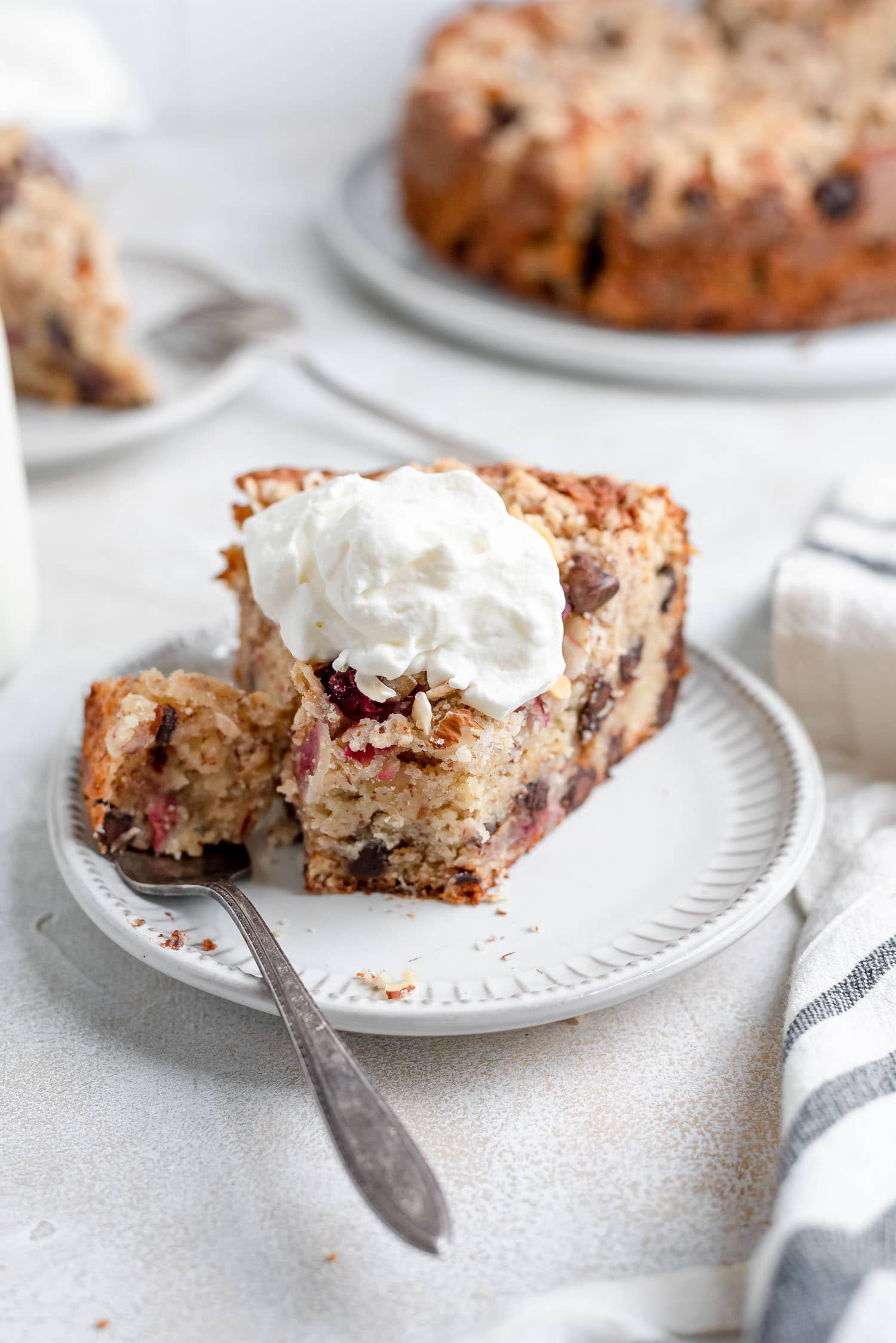 cake slice topped with whipped cream and piece missing