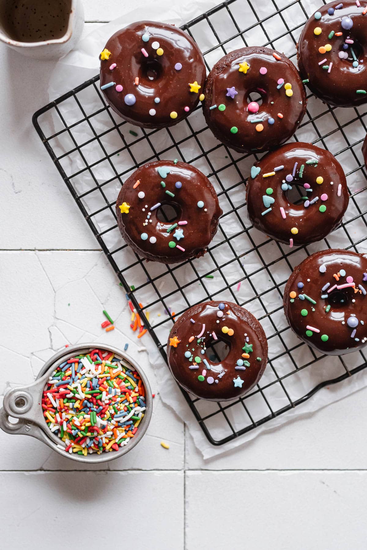 mini chocolate donuts on wire rack with sprinkles