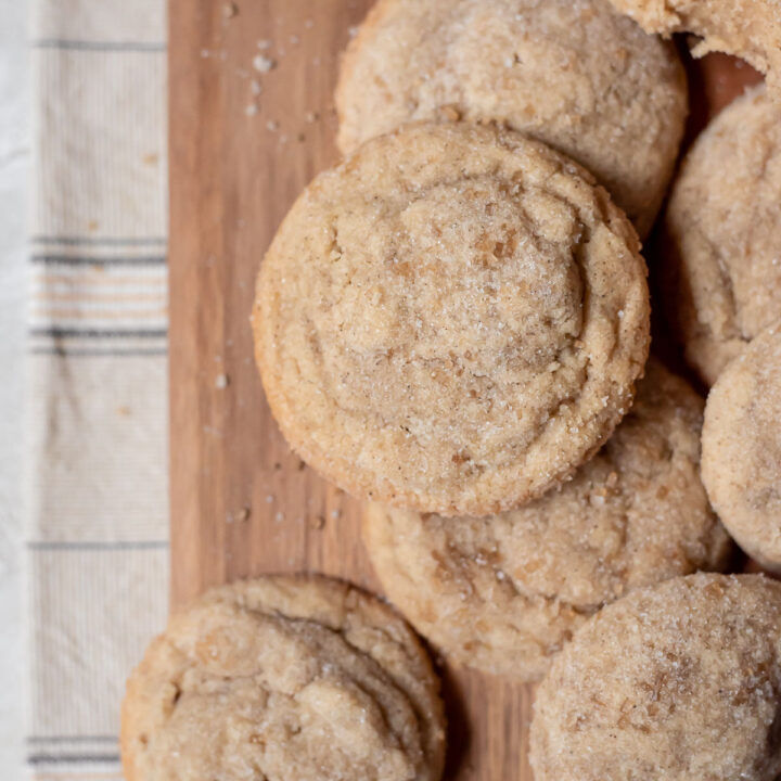 baked sugar cookies stacked on wood tray